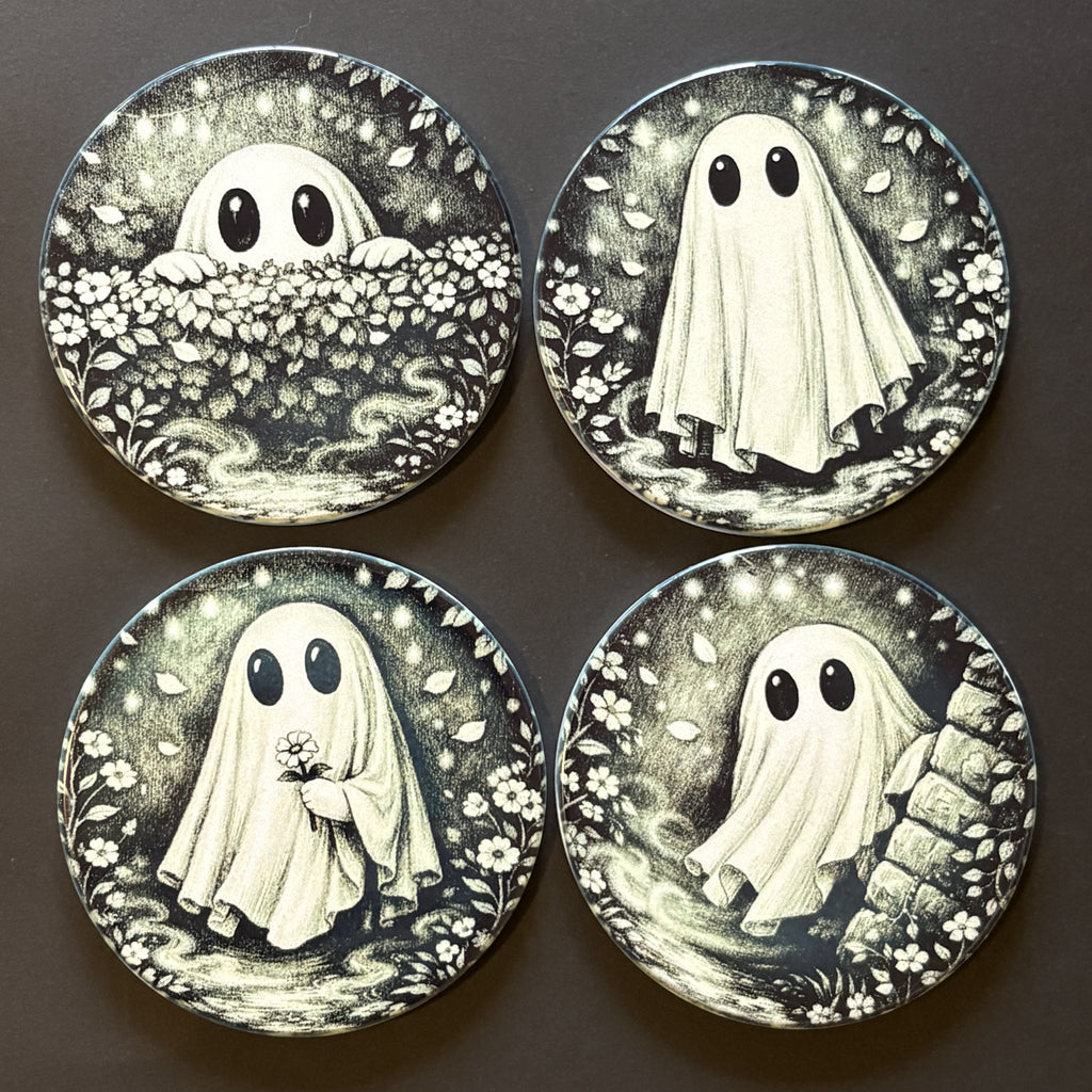 Four round decorative coasters featuring a black and white illustration of a ghost in different poses, arranged in a 2x2 grid on a dark background.