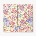 Four floral tiles with pink, blue, and purple flowers on a beige background