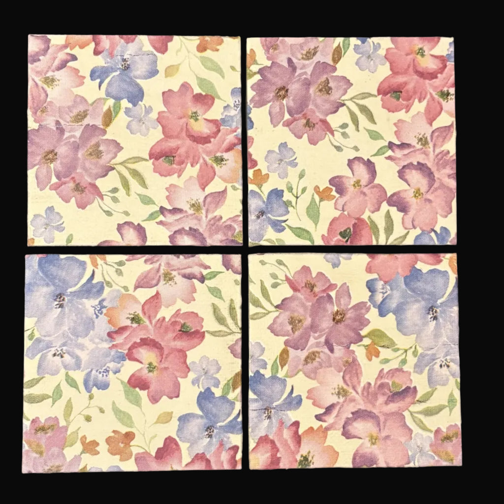 Four floral tiles with pink, blue, and purple flowers on a beige background.
