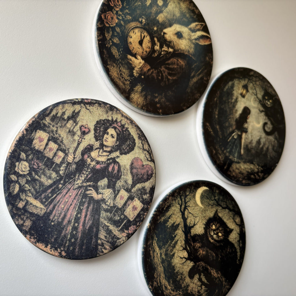 Four oval decorative coasters with whimsical vintage illustrations, including a clock and rabbit, a woman in a pink dress, a girl in a moonlit scene, and a cat under a crescent moon, arranged on a white background.