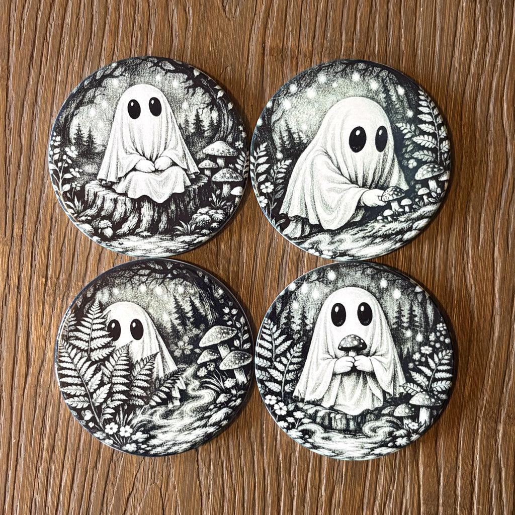 Four round coasters featuring black and white illustrations of cute ghosts in a forest, arranged in a 2x2 grid on a wooden surface.