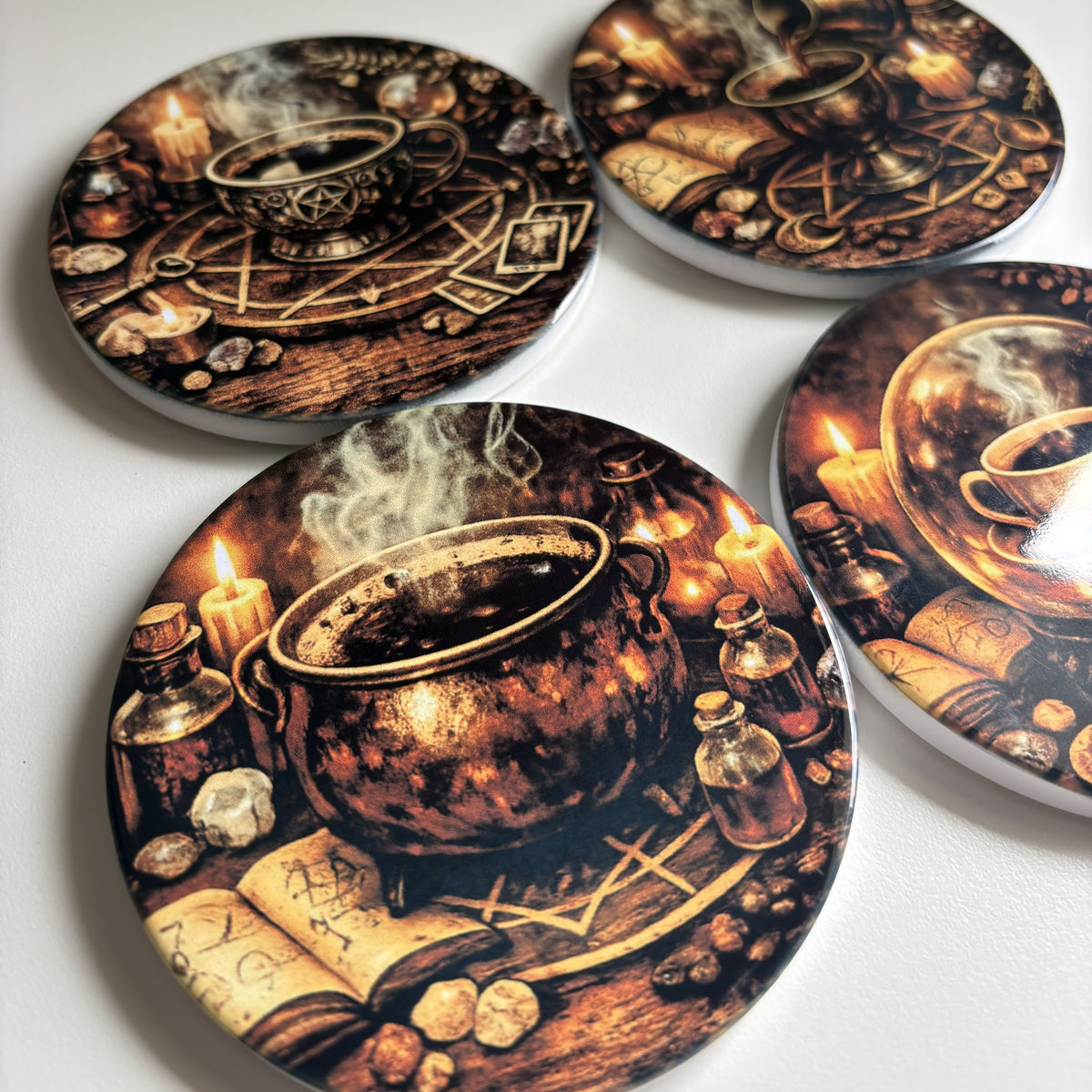Set of four coasters with vintage-style illustrations of cups, candles, and books on a dark background.