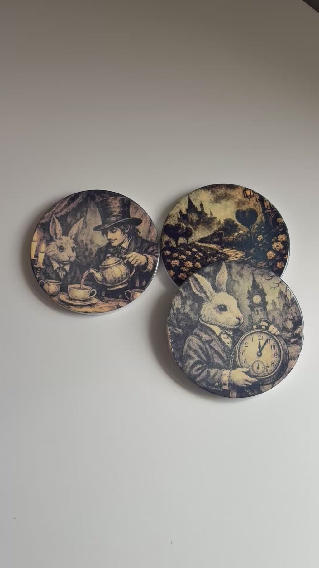 Four round coasters with vintage-style black and sepia illustrations of rabbits, a clock, a woman and rabbit, and a landscape path. 